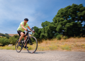 Bobbie LaPort is riding on her bike on a biking trail