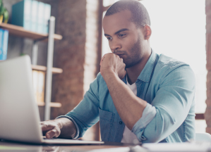 A man is thinking in front of his laptop