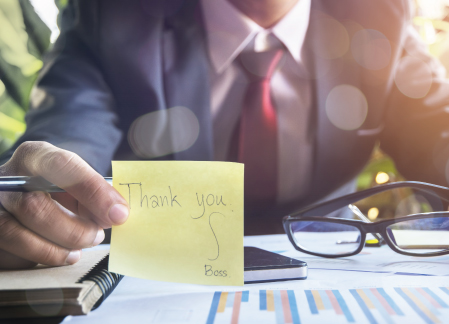 Cultivating a Culture of Gratitude - A man holding a sticky yellow note in front of the camera. "Thank You, Boss"