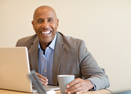 Man with laptop smiling at the camera